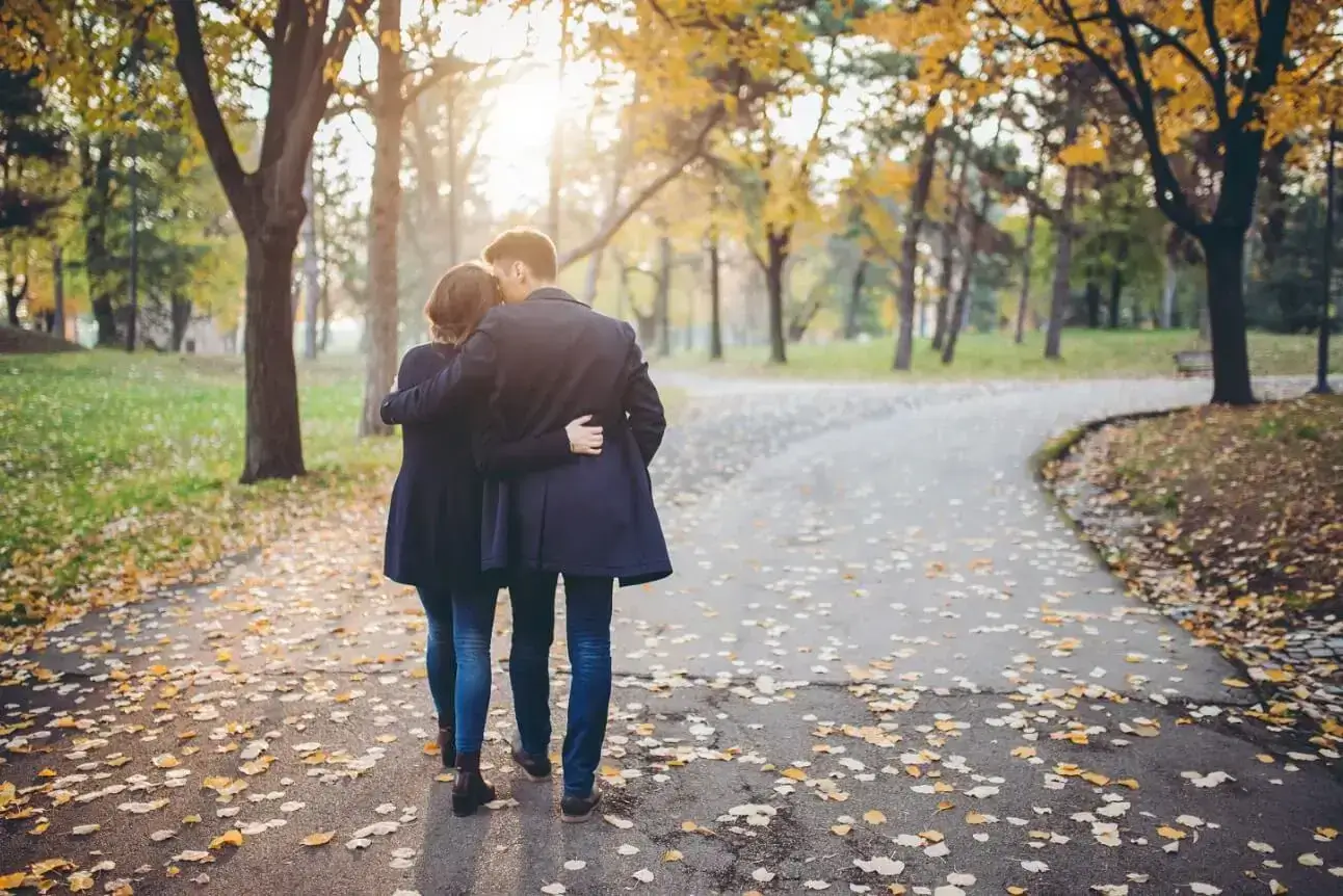 An image of a couple walking in a park.