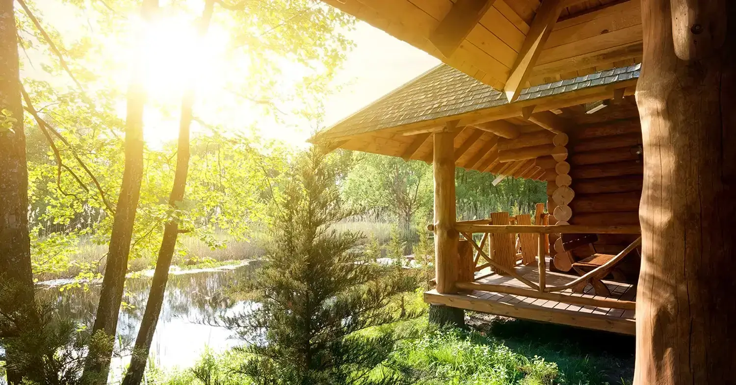 An angled view of a cabin by a pond.